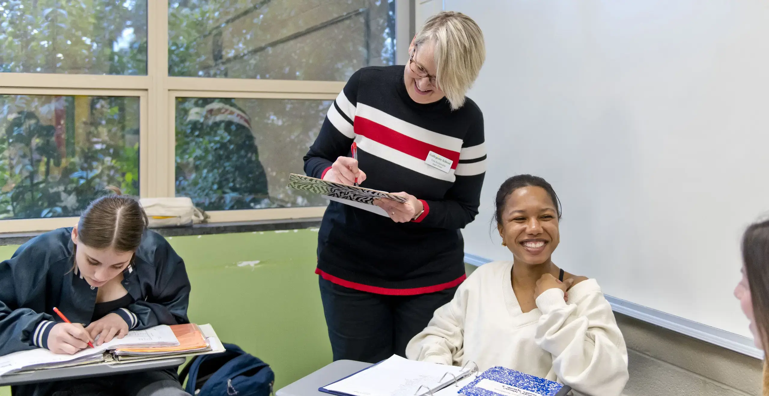 Teacher and students writing on a notebook