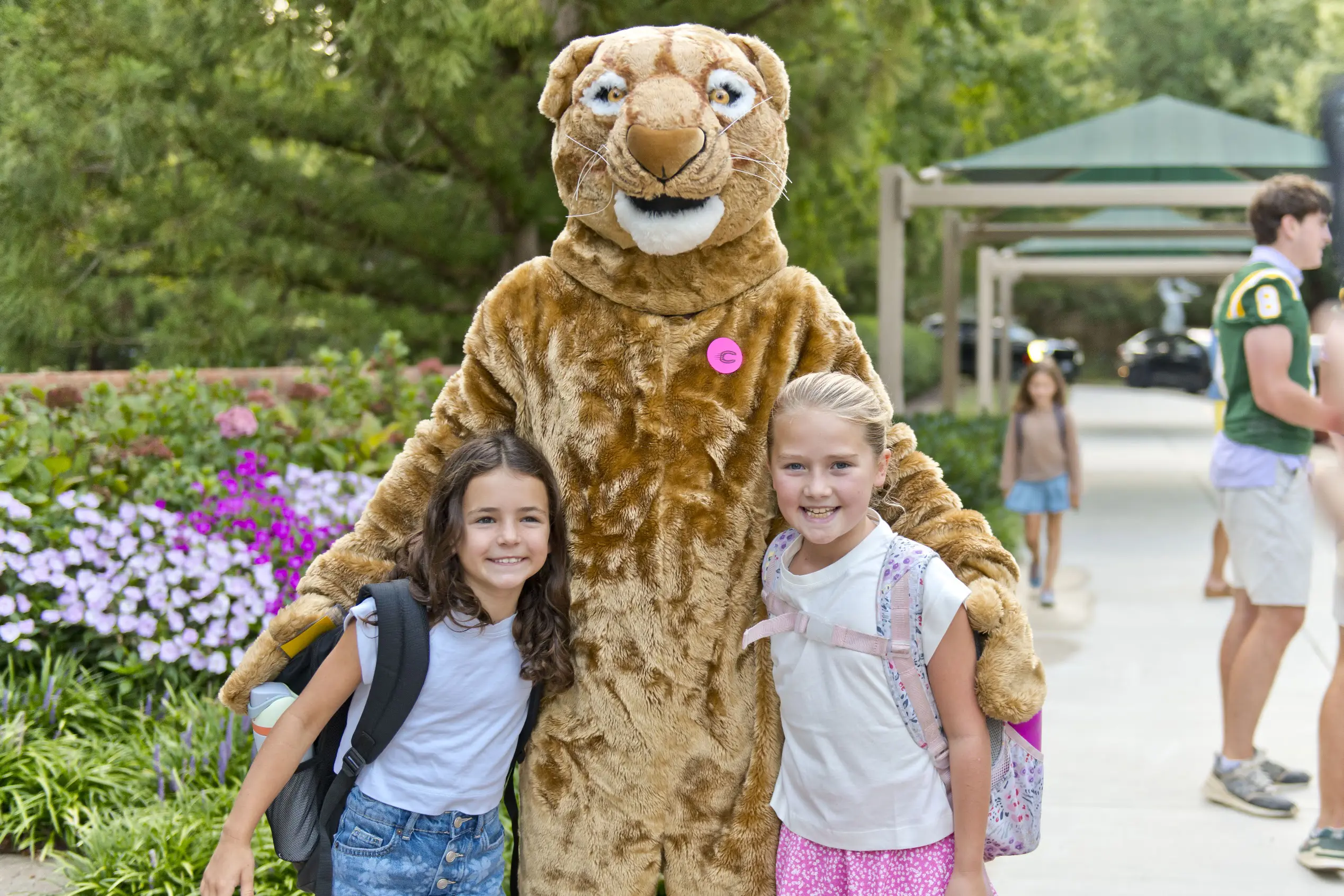 Students standing next to the school's mascot
