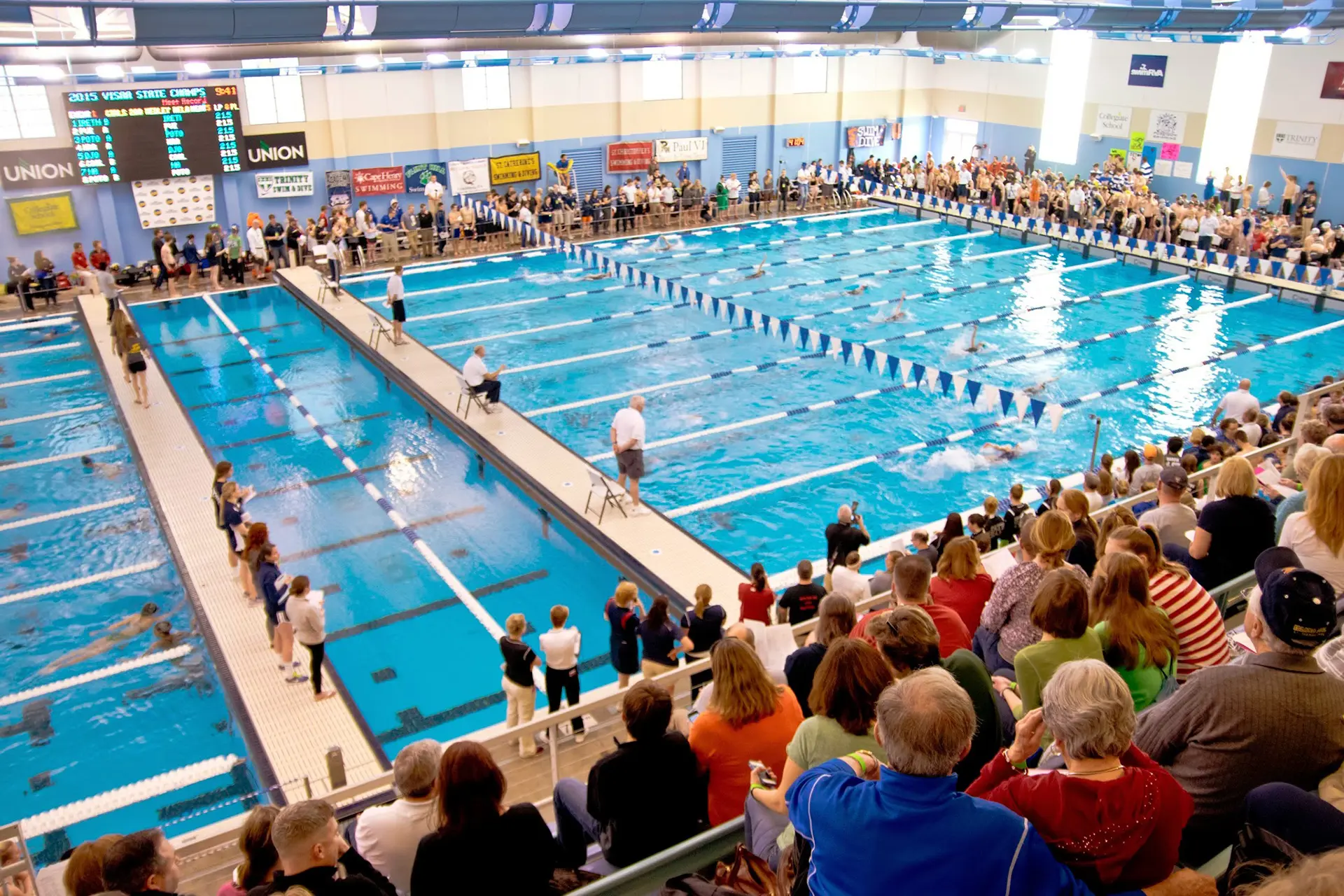 Indoor view of the Collegiate School Aquatics Center during a swim meet.