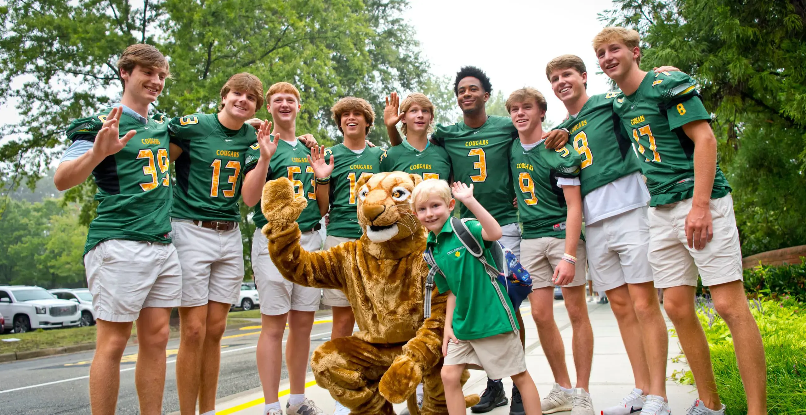 groups of students waiving alongside the school mascot