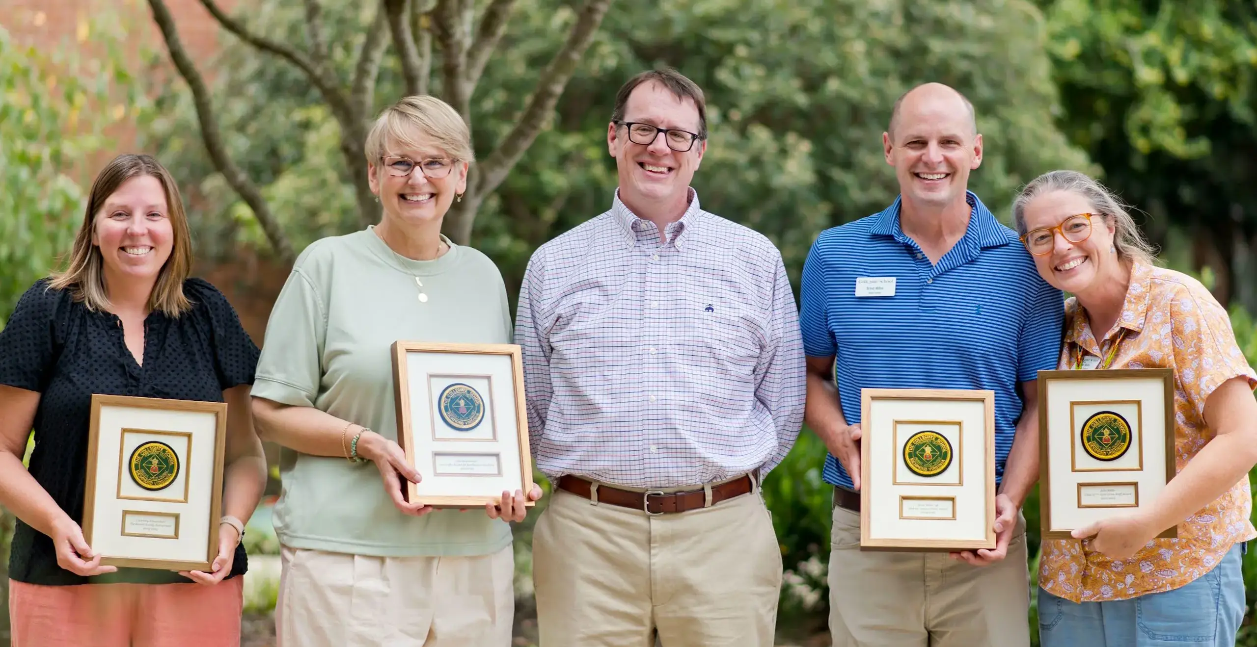Teachers smiling holding a certificate